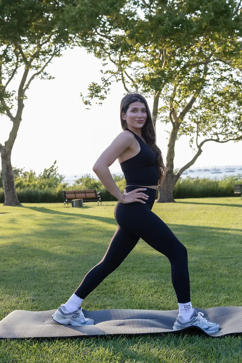 Student holding a deep lunge stretch on a Pilates mat