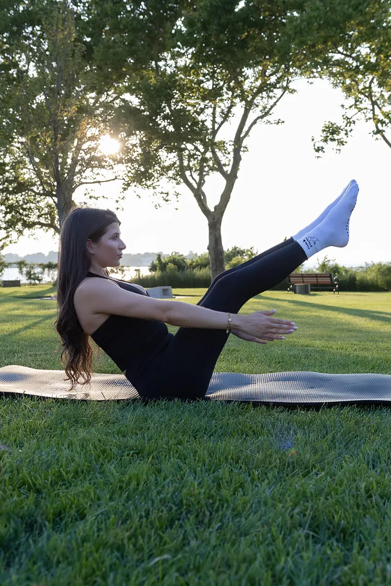 Student balancing in boat pose for core strength