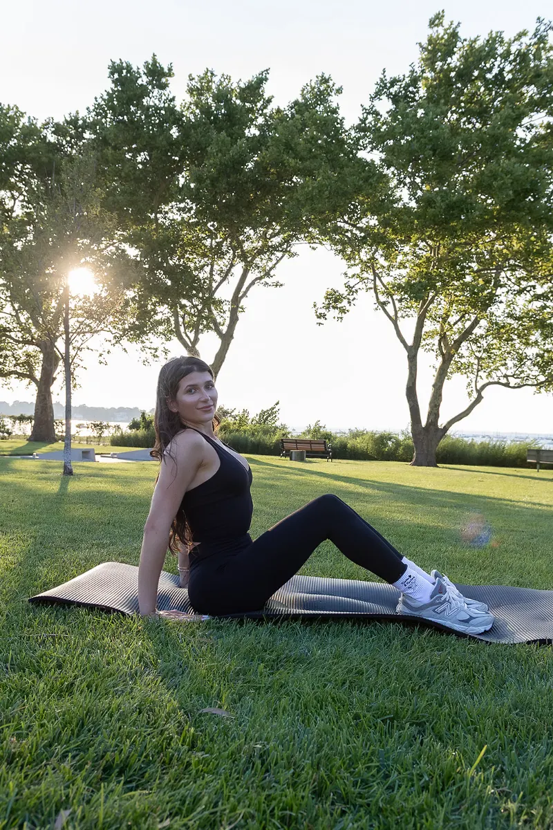 Student resting seated on a mat between Pilates sets